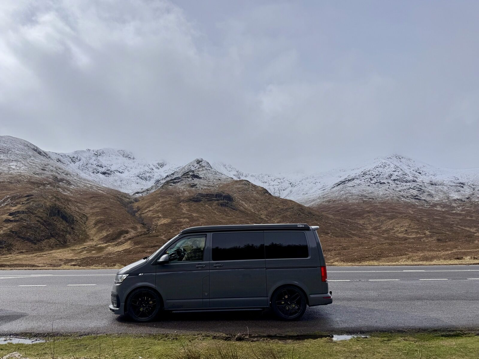 Vincent, a VW T6.1 campervan, parked before snow-capped Scottish mountains